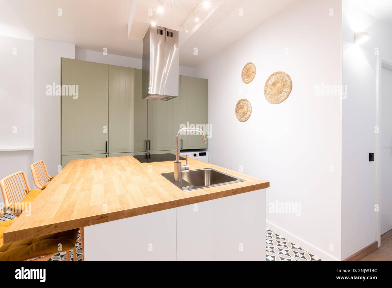 Cuisine design avec éclairage mural lumineux. Table avec évier et en métal chromé. Au