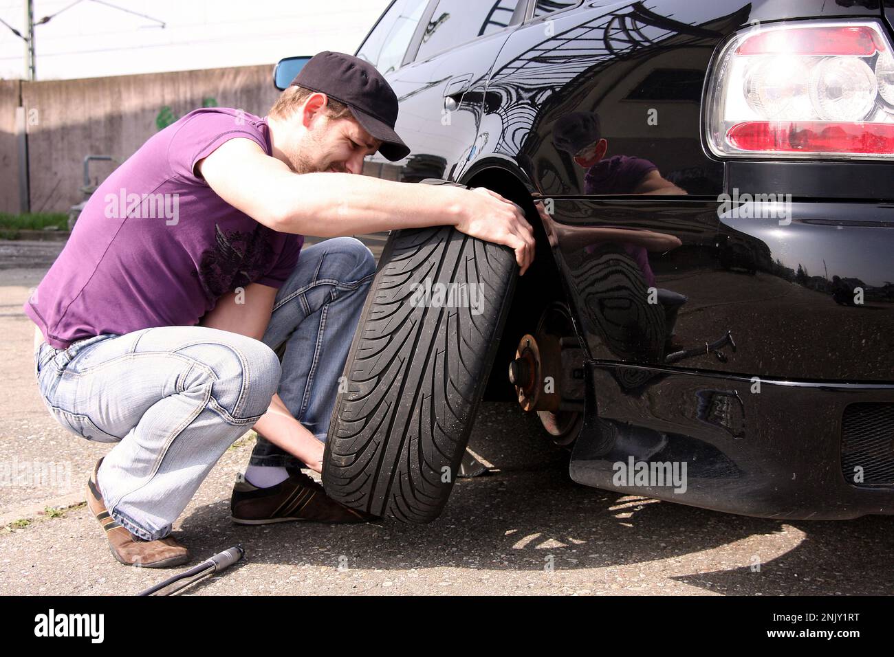 changement de pneu, jeune homme change les pneus d'hiver en pneus sommer, photo de série 8/9 Banque D'Images