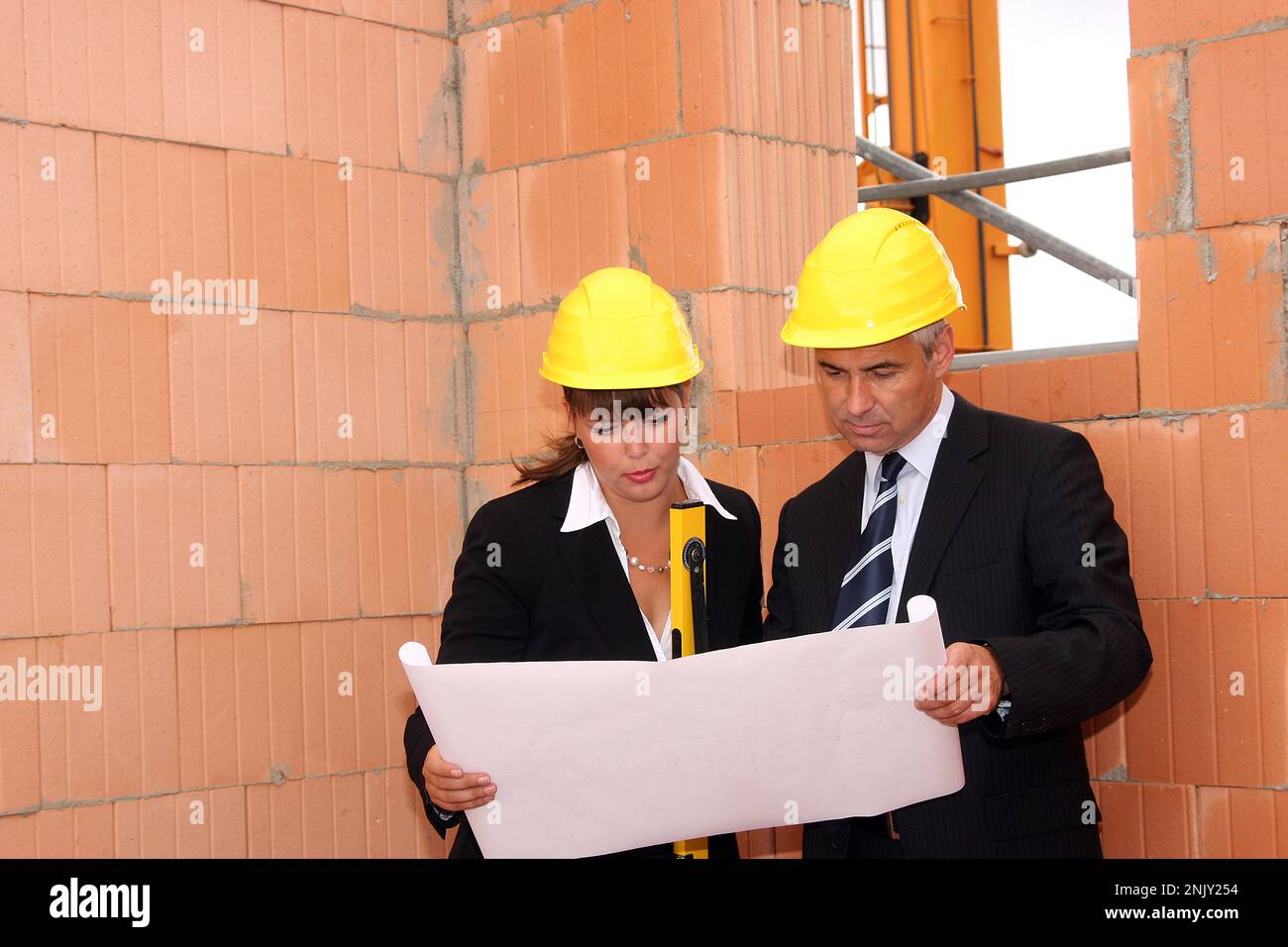 Architectes sur le chantier regardant le dessin de construction Banque D'Images