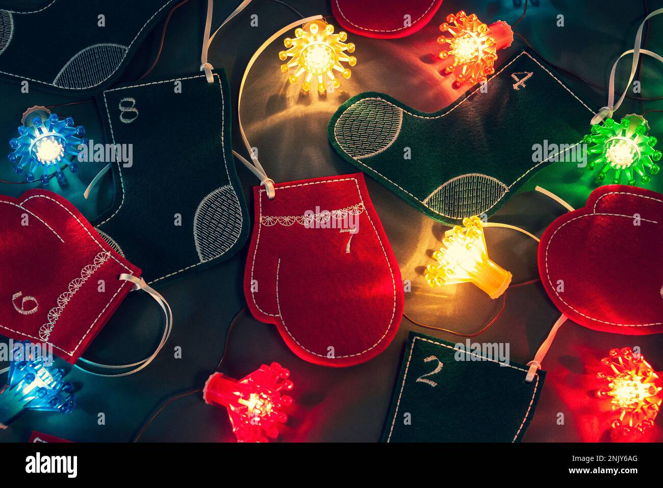 Bas en feutre, mitaines et lumières de fées comme belle décoration de maison de Noël. Calendrier de l'Avent pour les enfants. En attendant les vacances Banque D'Images