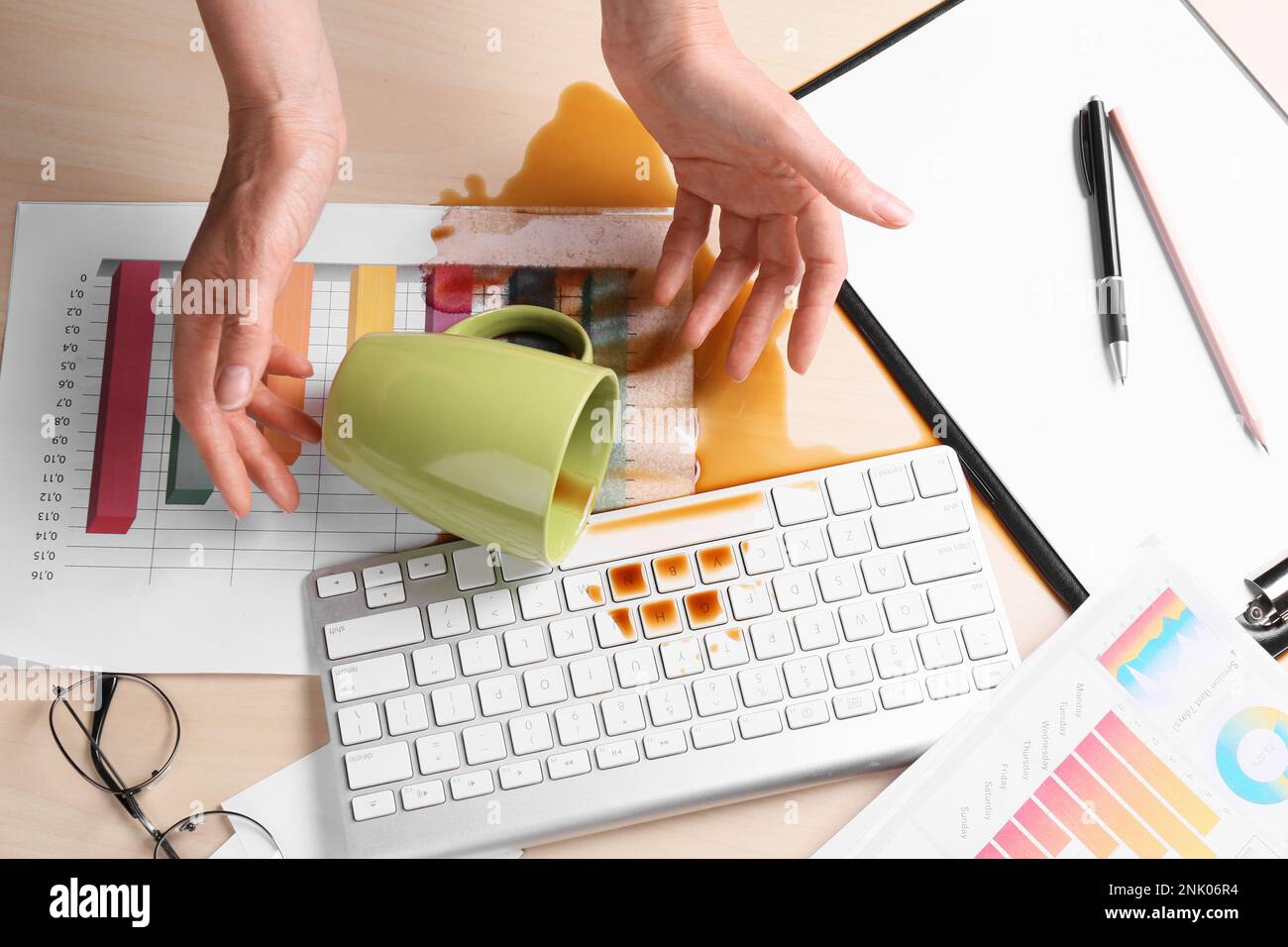 Femme avec du café renversé sur son lieu de travail, au-dessus de la vue Banque D'Images Femme avec du café renversé sur son lieu de travail, au-dessus de la vue Banque D'Images