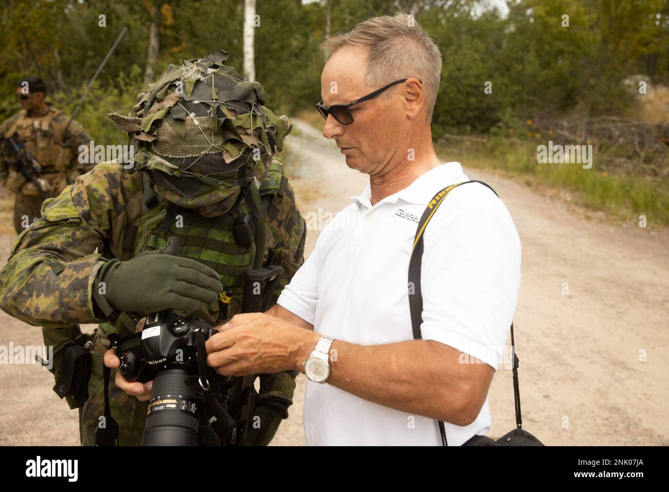 Un soldat finlandais regarde la photographie d’un représentant des médias finlandais pendant la journée des médias à Upinniemi, en Finlande, le 17 août 2022. Le Kearsarge amphibie Ready Group et 22nd MEU, sous le commandement et le contrôle de la Task Force 61/2, sont en cours de déploiement aux États-Unis Marine Forces Europe zone d'opérations, employée par les États-Unis Sixième flotte pour défendre les intérêts des États-Unis, des alliés et des partenaires. Banque D'Images