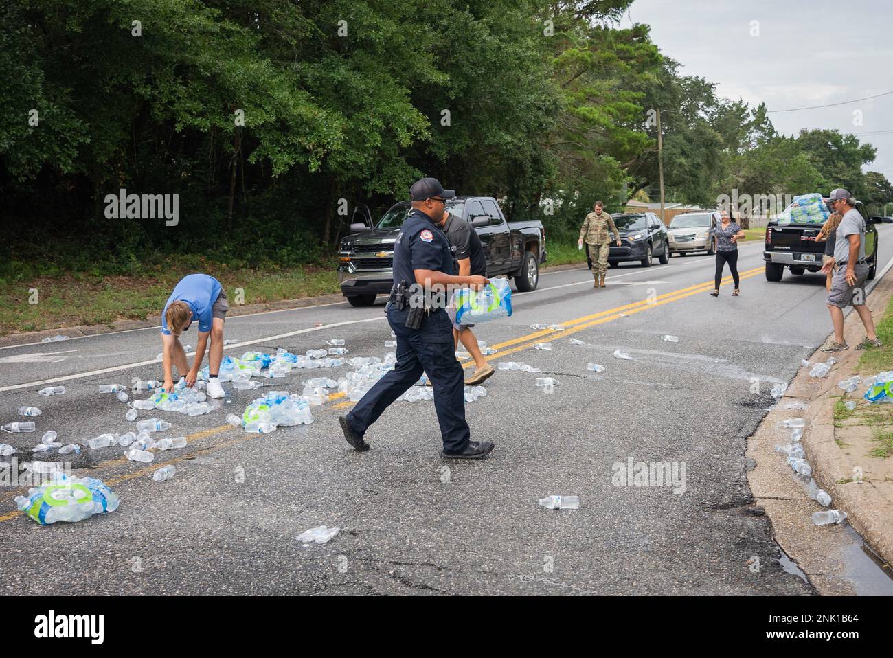 Le sergent d'état-major Gerard Bhagswatsingh, défenseur de l'escadron 919th des opérations spéciales des forces de sécurité et agent de police communautaire du département de police de fort Walton Beach, aide à ramasser les bouteilles d'eau tombées sur la route à fort Walton Beach, en Floride, le 10 août 2022. Les agents de la division des services de police communautaires établissent des rapports et des relations avec les citoyens locaux dans le cadre d'une approche proactive de la prévention du crime. Banque D'Images