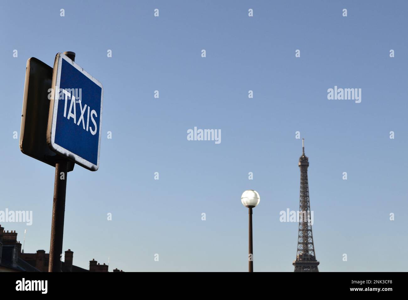 Horizon de Paris le matin avec la Tour Eiffel et des éléments urbains tels que: Un panneau de taxi, cheminées, lumière de rue. Banque D'Images