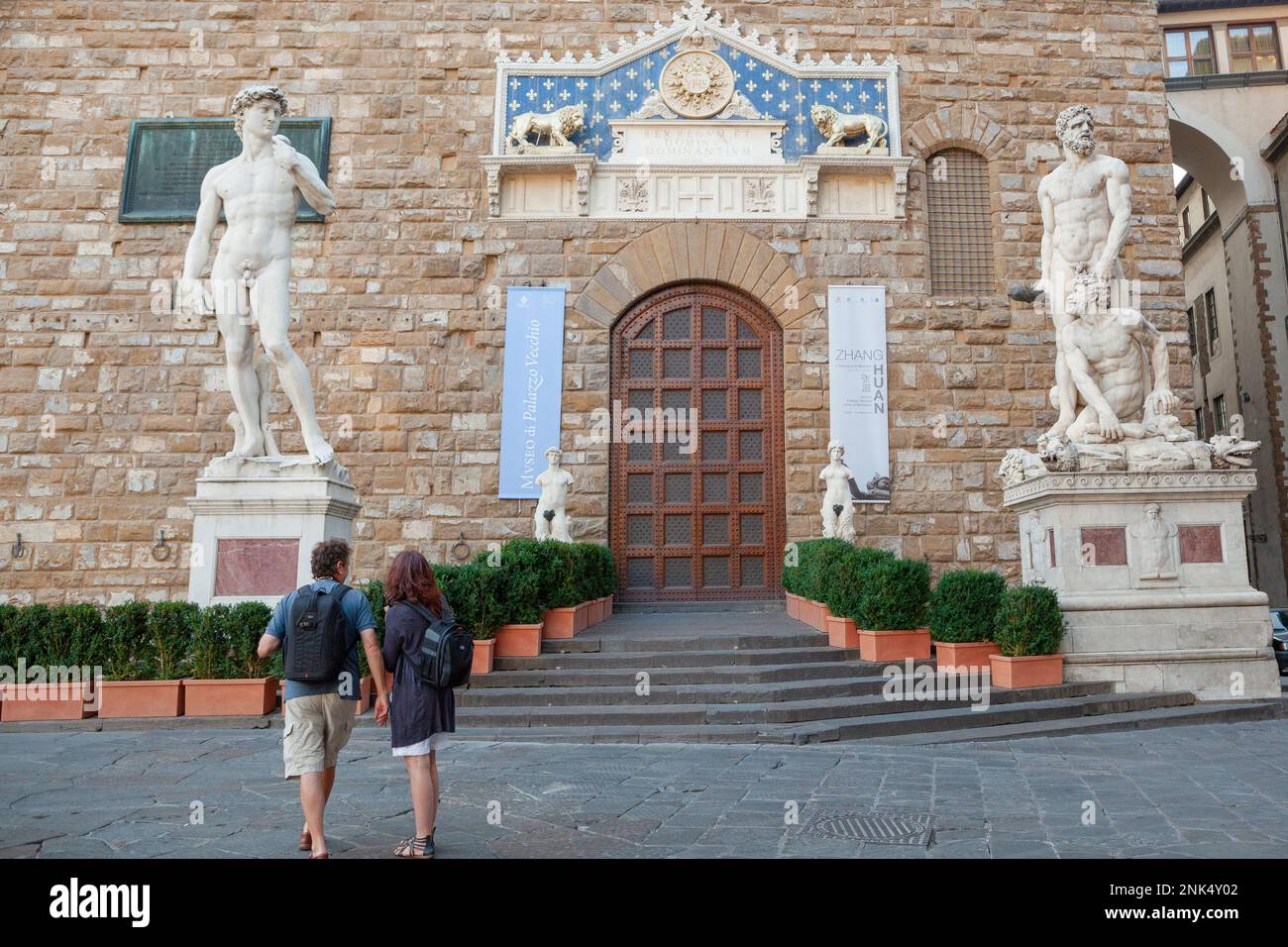 Un couple touristique admirera les anciennes statues en marbre à l'extérieur du Museo di Palazzo Vecchio à Florence, Toscane, Italie. Banque D'Images