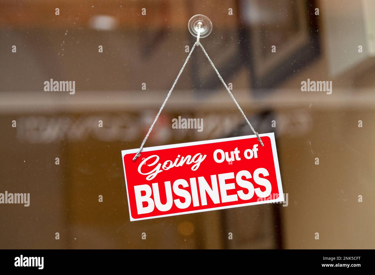 Affiche rouge accrochée à la porte vitrée d'un magasin indiquant : « sortir du commerce ». Banque D'Images