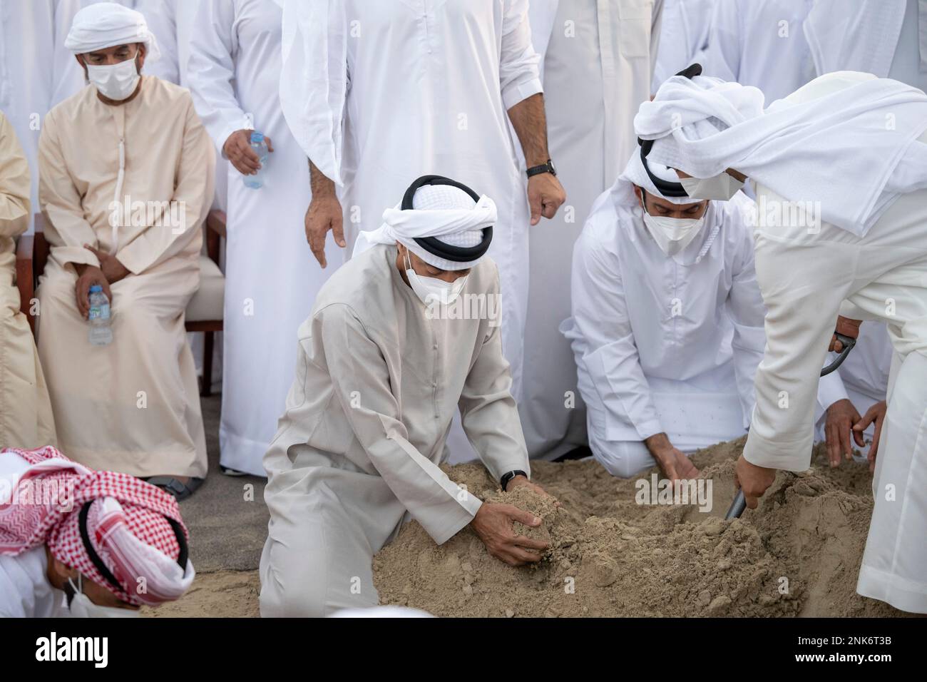 This photo made available by the Ministry of Presidential Affairs, shows Sheikh Mohamed bin Zayed Al Nahyan, Ruler of Abu Dhabi, center, and Sheikh Mansour bin Zayed Al Nahyan, UAE Deputy Prime Minister and Minister of Presidential Affairs, right, attend the burial of Sheikh Khalifa bin Zayed Al Nahyan, President of the United Arab Emirates, with other members of royal family at Al Bateen cemetery, in Abu Dhabi, Friday, May 13, 2022. (Abdulla Al Junaibi/Ministry of Presidential Affairs via AP) Banque D'Images