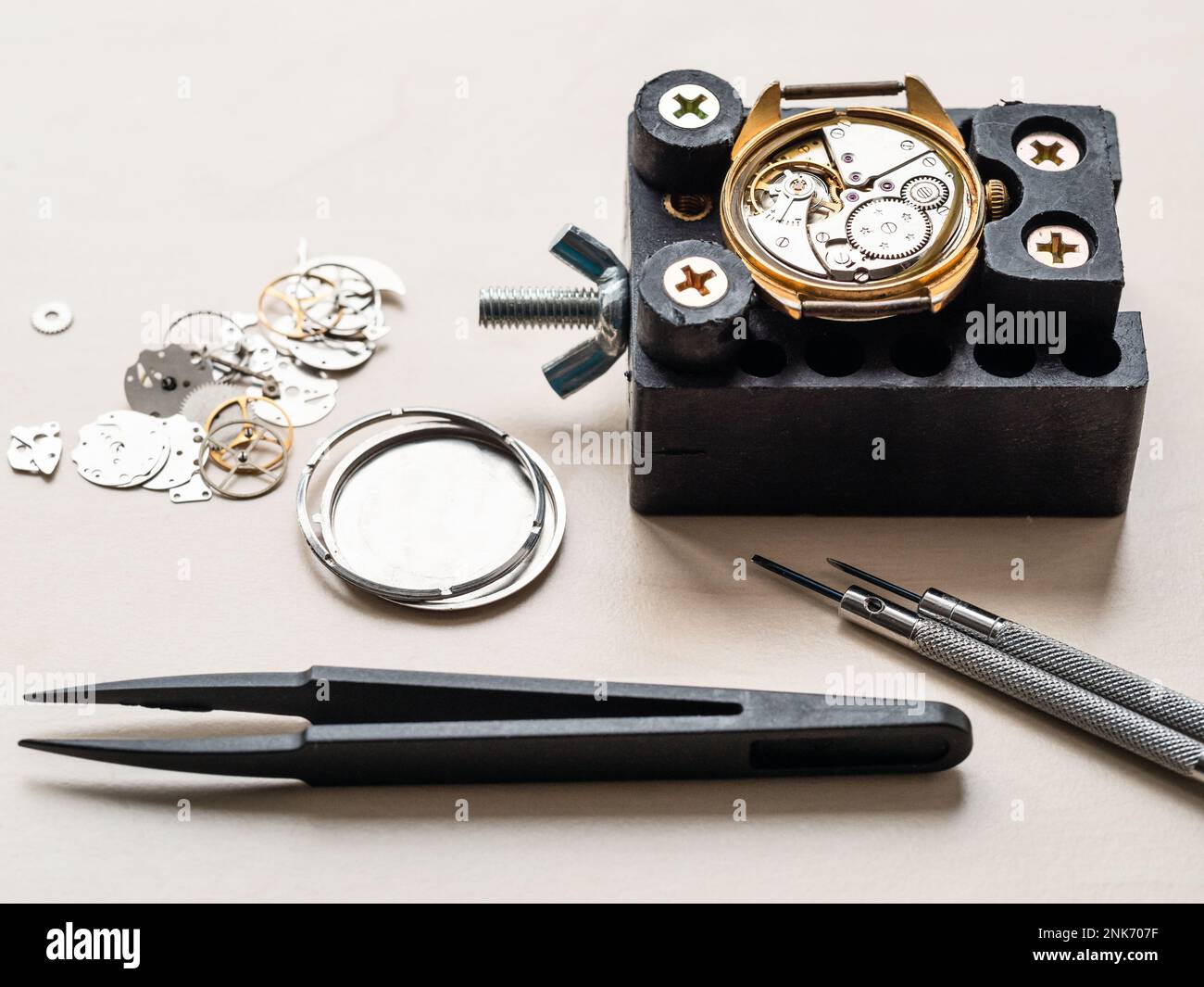 outils et montre ouverte dans le support sur une table en bois dans l'atelier horloger Banque D'Images