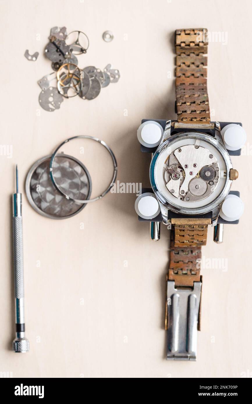 au-dessus de la vue de l'ancienne montre-bracelet avec bracelet rouillé sur une table en bois dans l'atelier horloger Banque D'Images
