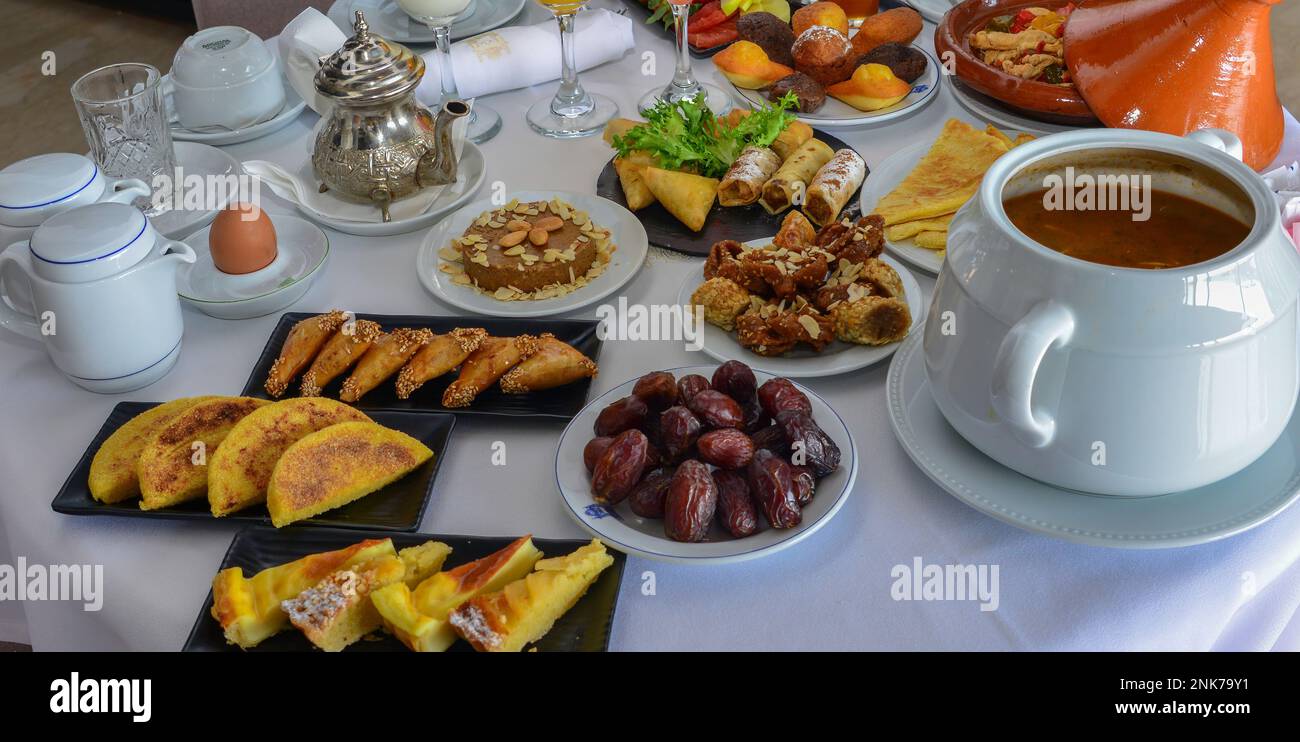 Petit déjeuner marocain au Ramadan. Soupe de harira. Dattes, thé, jus de fruits et divers sucreries Banque D'Images