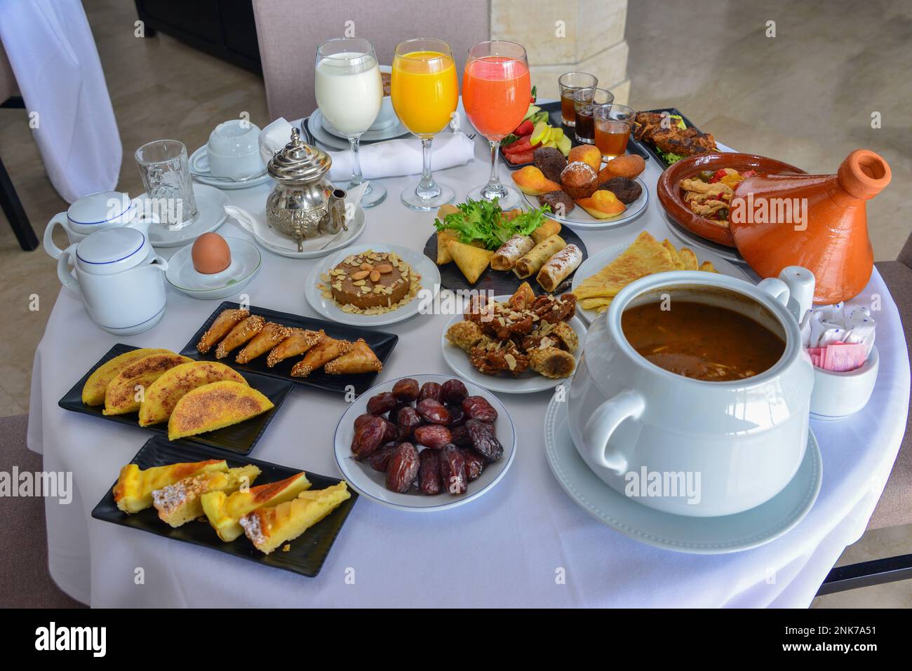 Petit déjeuner marocain au Ramadan. Soupe de harira. Dattes, thé, jus de fruits et divers sucreries Banque D'Images