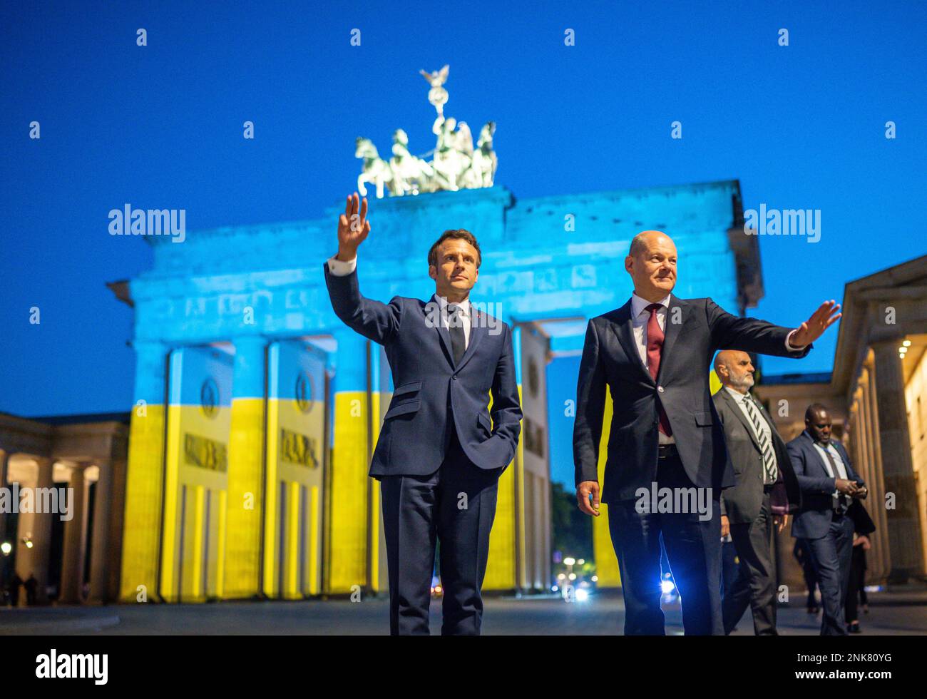 German Chancellor Olaf Scholz, right, and French President Emmanuel Macron stand in front of the Brandenburg Gate after a meeting in Berlin, Monday, May 9 2022. To mark Europe Day, the Brandenburg Gate is illuminated in Ukraine's national colors. (Michael Kappeler/dpa via AP) Banque D'Images