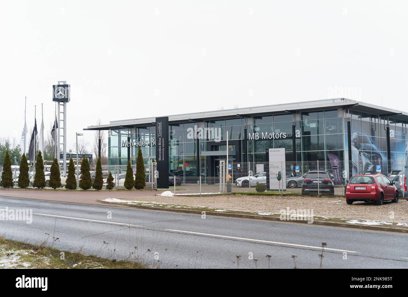 Poznan, Pologne - 25 janvier 2023: Mercedes Benz salle d'exposition de voiture, à côté derrière une clôture en maille sont de nouvelles voitures. Banque D'Images