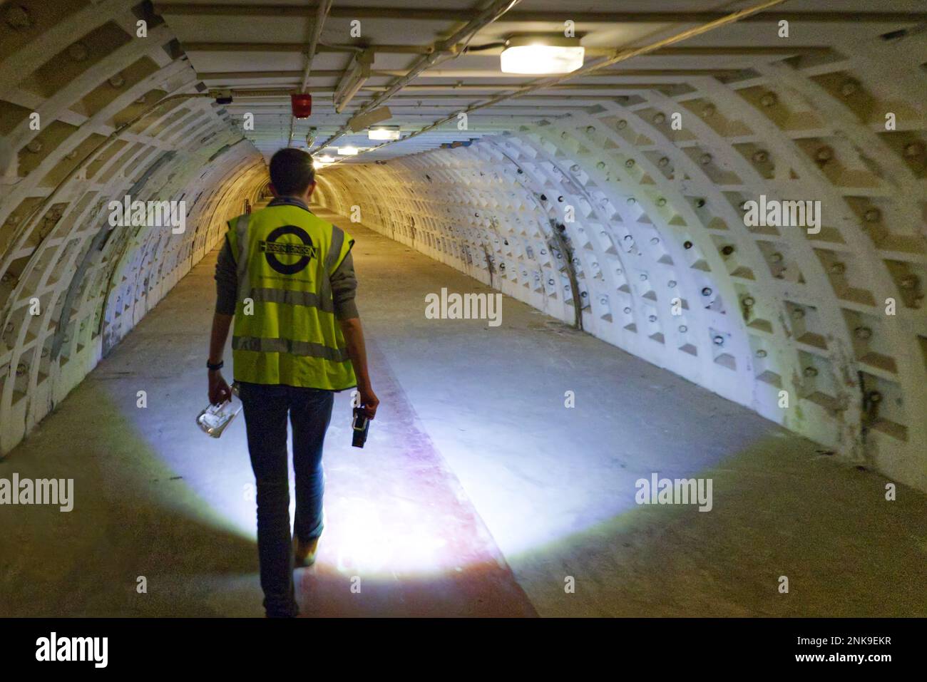 Londres, Angleterre, Royaume-Uni - le guide mène la visite à la lumière de la torche dans le tunnel de Clapham South Deep-Level Shelter construit pendant la Seconde Guerre mondiale comme un abri de RAID aérien Banque D'Images