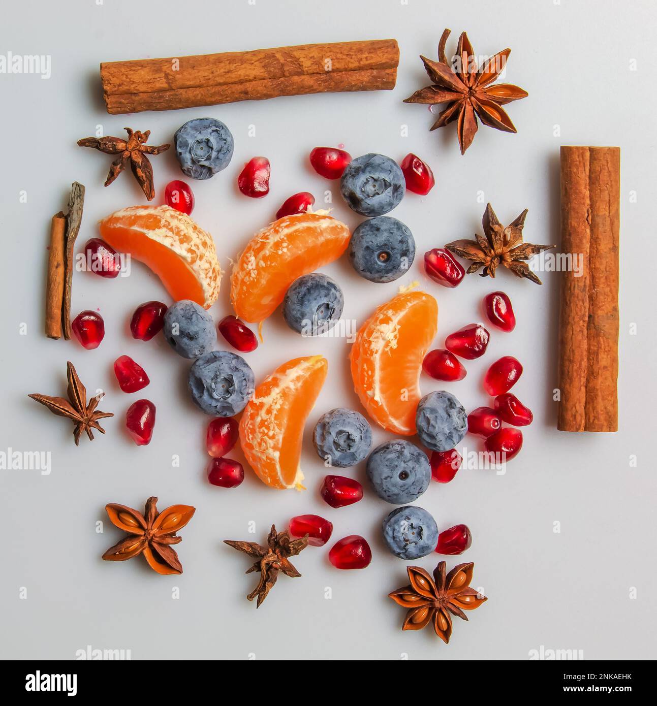 Ensemble de fruits et d'épices de saison pour les boissons et les repas d'hiver. Bâtonnets de cannelle, anis étoilé, graines de grenade, mandarine, myrtille. Fond d'épice Banque D'Images