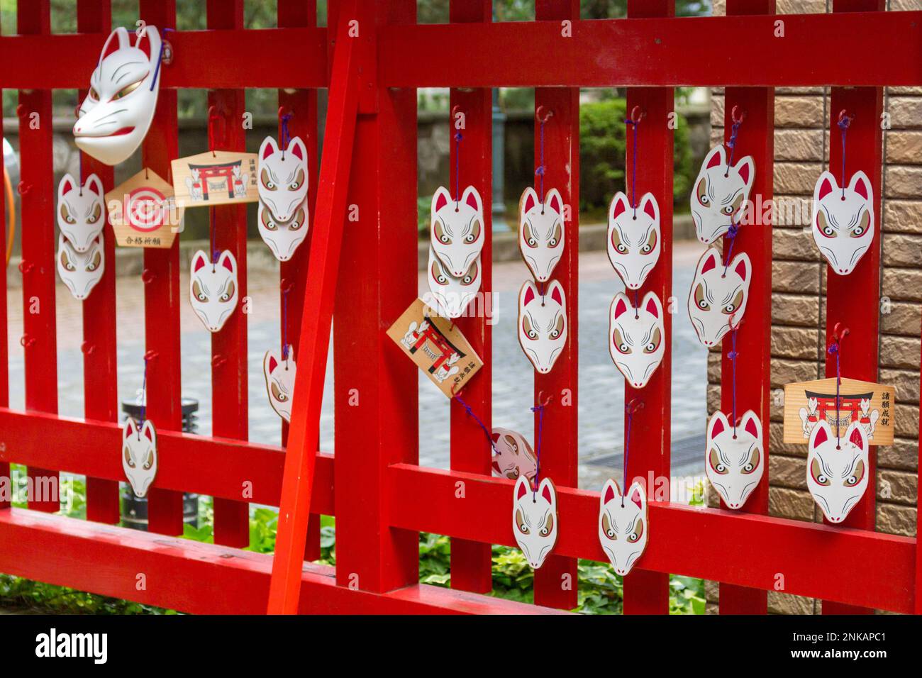 Masques de renard rouge et blanc et plaques de prière ema à Asanogawa inari jinja, Kanazawa, Japon. Banque D'Images