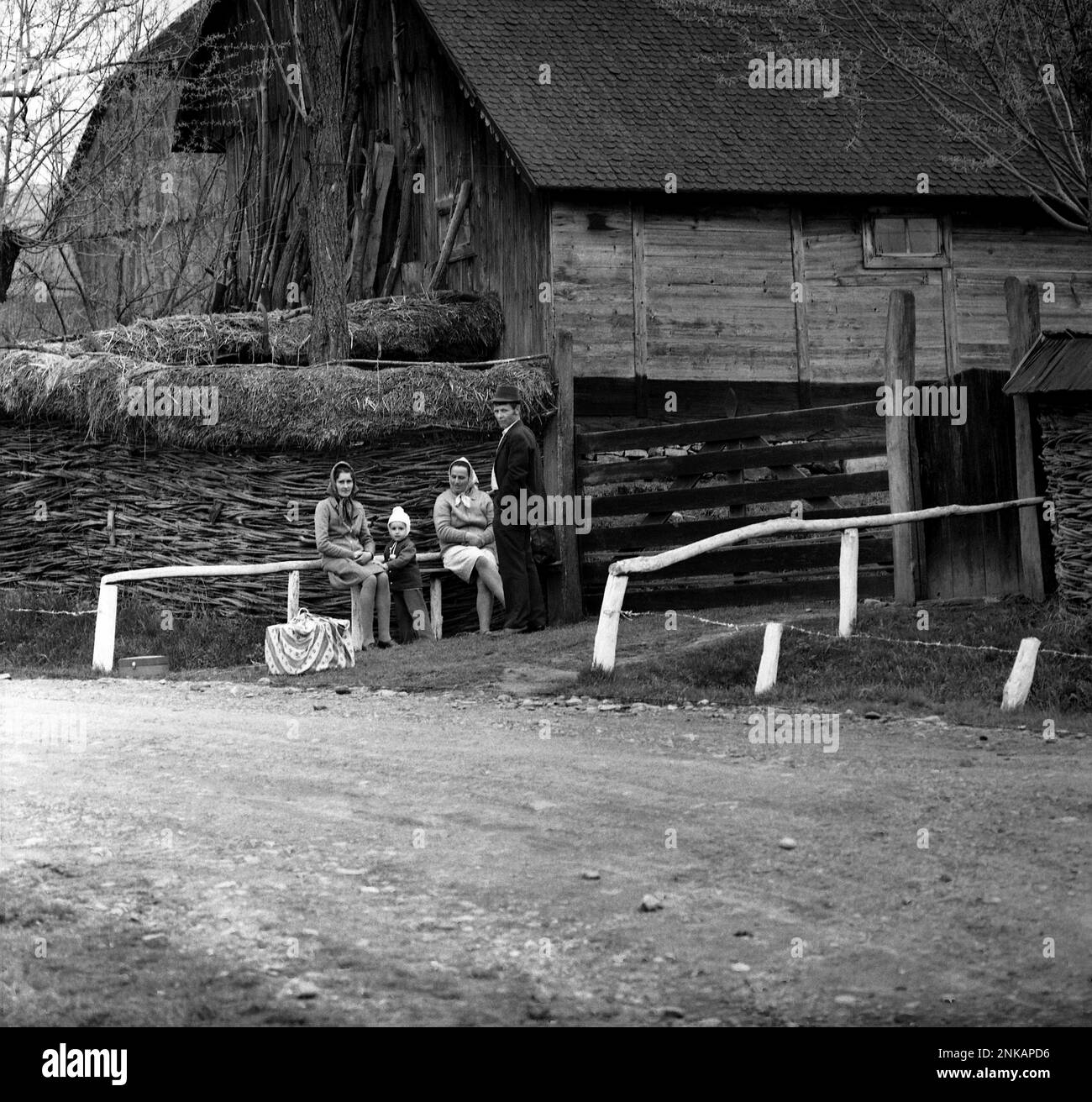 Comté de Suceava, République socialiste de Roumanie, env. 1980. Les habitants de la région attendent sur le côté d'une route non pavée dans la campagne. Banque D'Images