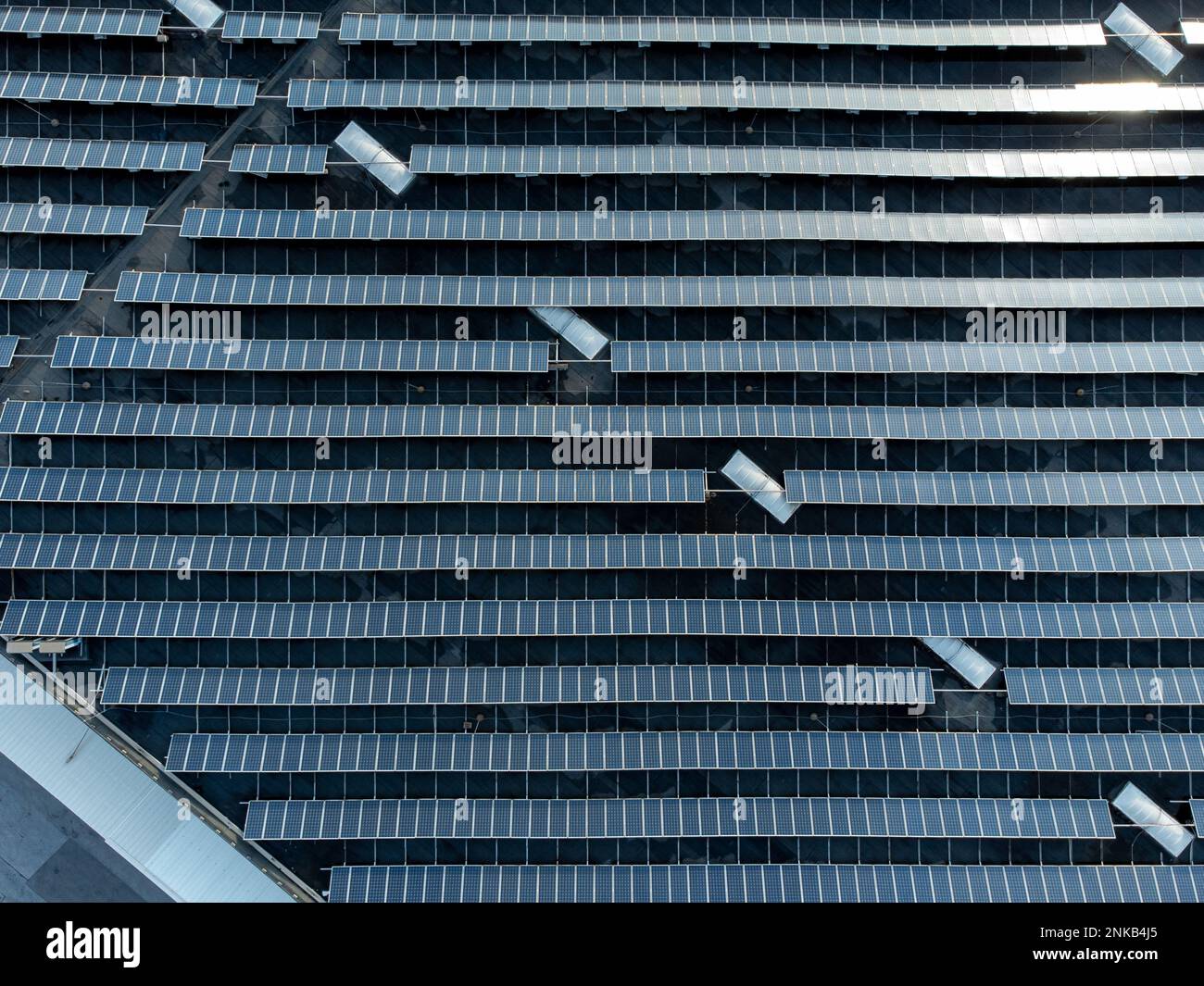 Grande ferme empilée de panneaux solaires sur un bâtiment d'entrepôt de distribution, vue aérienne en haut vers le bas Banque D'Images