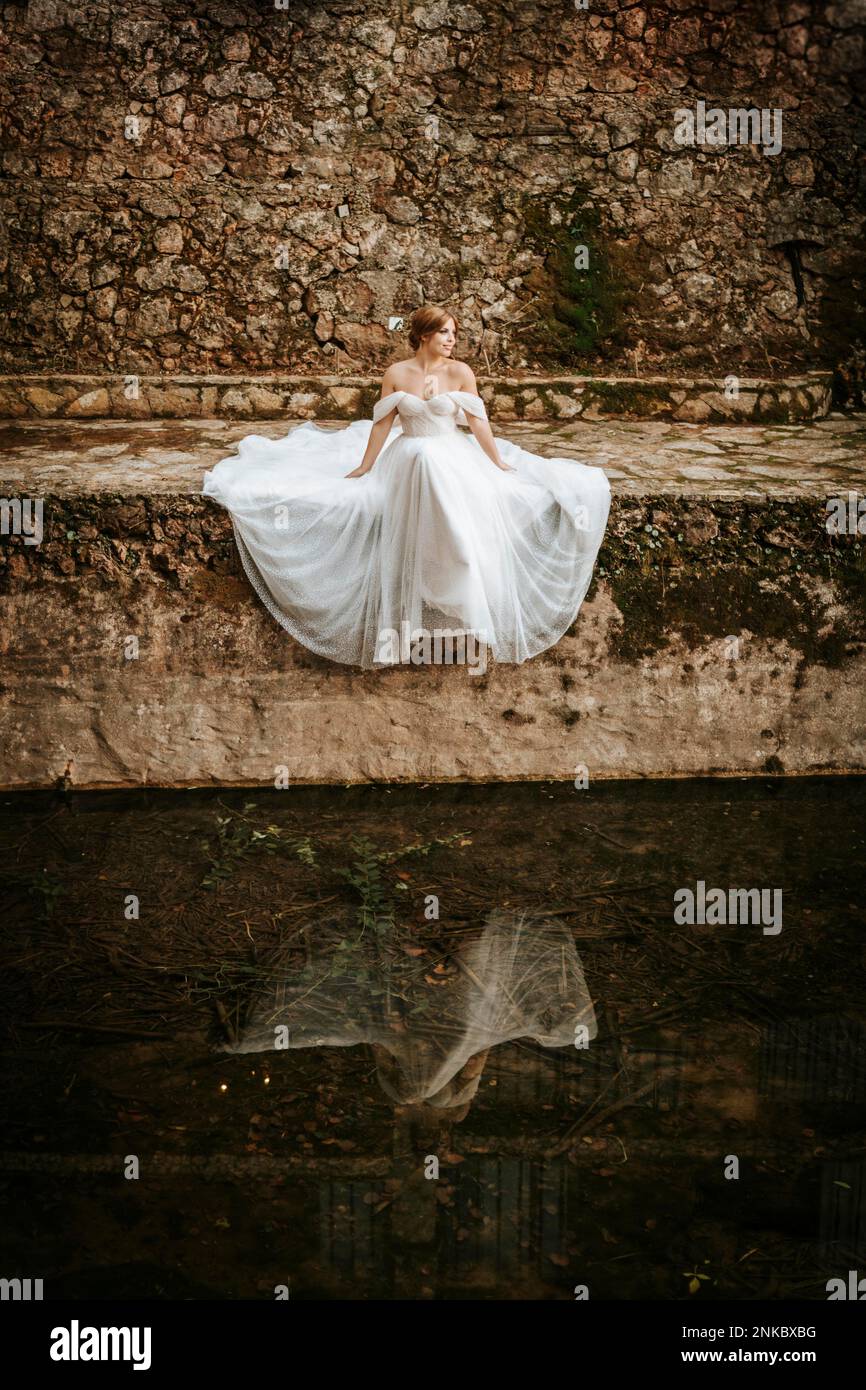 Portraits rêveux d'une belle mariée sur une rive en pierre Banque D'Images