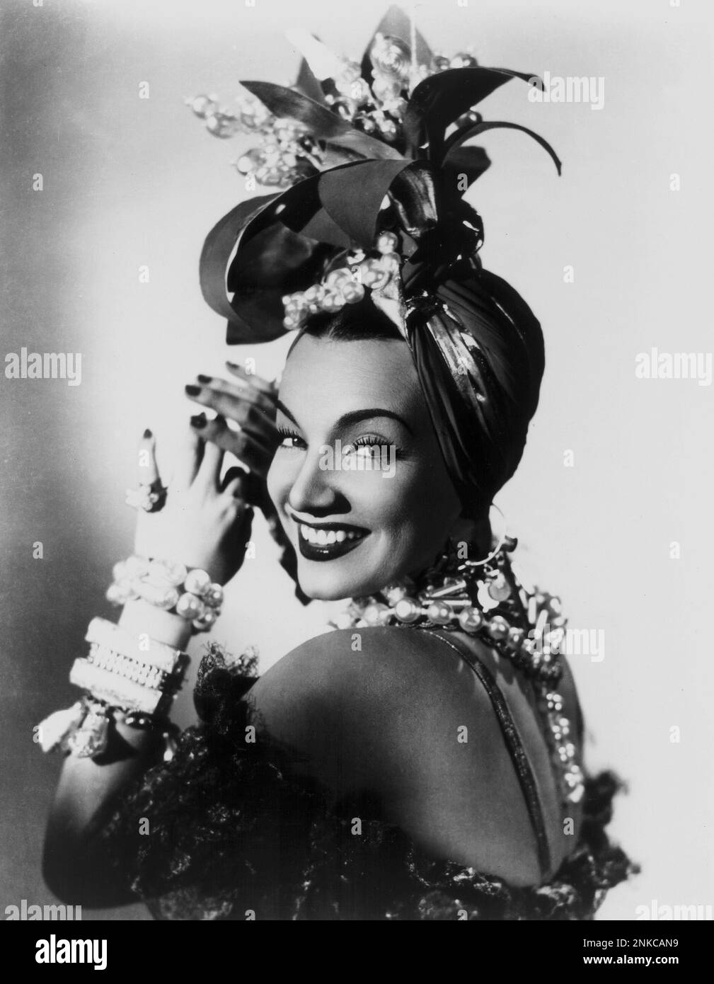 1941 : l'actrice et danseuse brésilienne CARMEN MIRANDA ( 1909 - 1955 ) dans CETTE NUIT À RIO ( una notte a Rio ) - CINÉMA - FILM - chapeau - cappello - bijoux - bijoux - gioiello - gioielli - perles - perla - perle - sourire - sorriso - bracelets - bracciale - bracciali - braccialetto - spalla - spalle - épaules - schiena - dos ---- Archivio GBB Banque D'Images