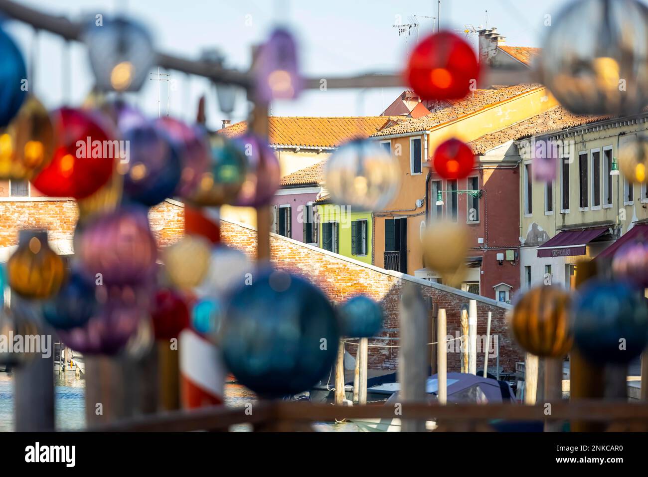 L'art du verre est suspendu dans les ruelles en face des maisons colorées, l'île de Murano, Venise, Italie Banque D'Images