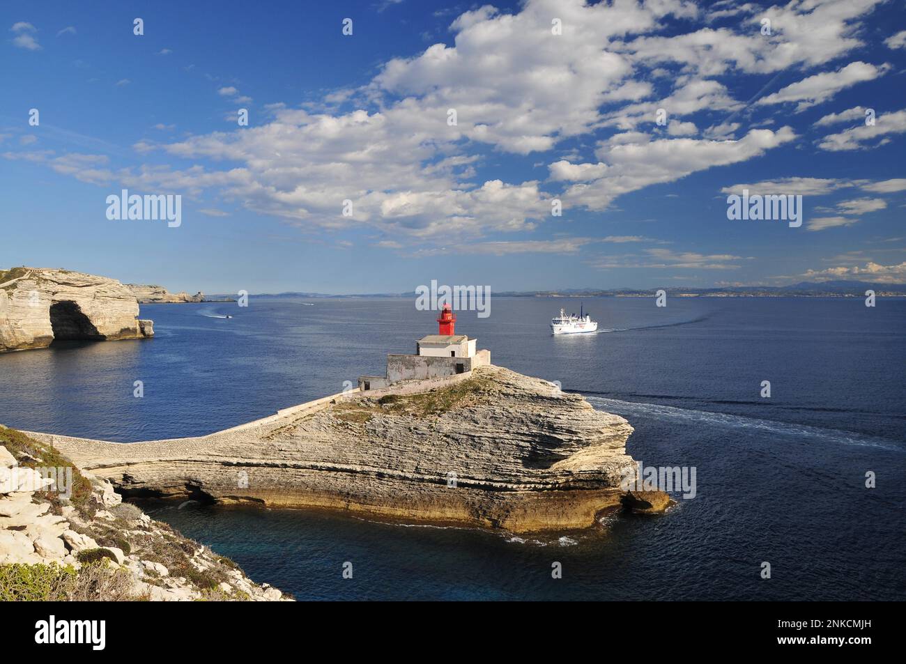 Le phare Phare de la Madonette à l'entrée du port de Bonifacio, en arrière-plan Sardaigne, Corse, France Banque D'Images