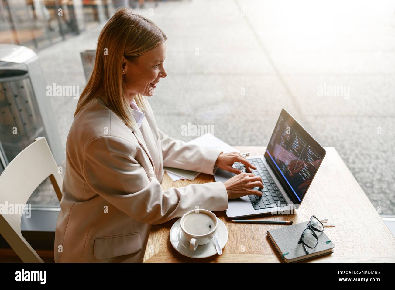Femme indépendante de programme travaillant sur ordinateur portable tout en étant assise dans un café. Données correctes Banque D'Images