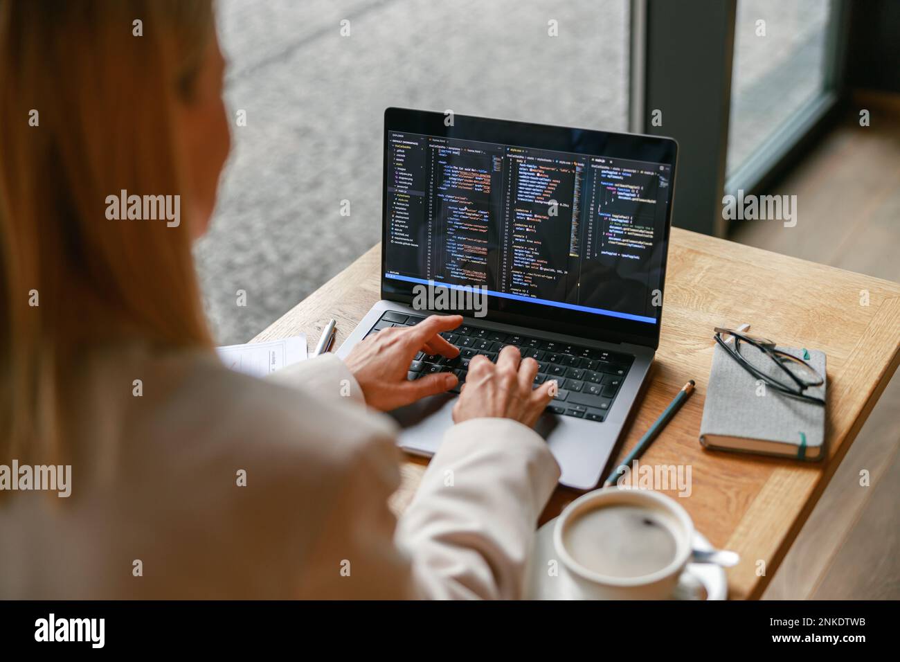 Gros plan sur une femme indépendante qui travaille sur un ordinateur portable tout en étant assise dans un café. Données correctes Banque D'Images