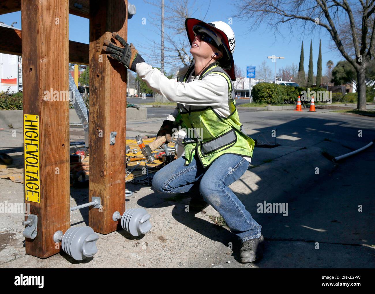 Sacramento Municipal Utility District worker Lindsey Martinez prepares a new utility pole for installation on Fairfield Street in Sacramento, Calif. on Friday, March 15, 2019. SMUD is one of the largest publicly operated electric utility companies in Northern California. (Paul Chinn/San Francisco Chronicle via AP) Banque D'Images