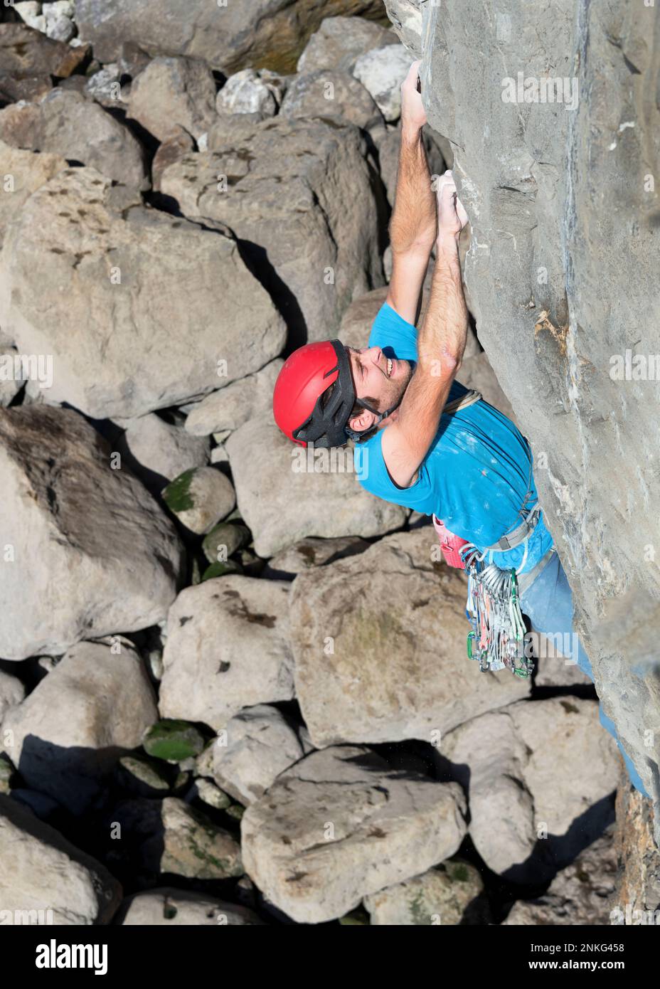 Sportif déterminé grimpant sur des rochers Banque D'Images