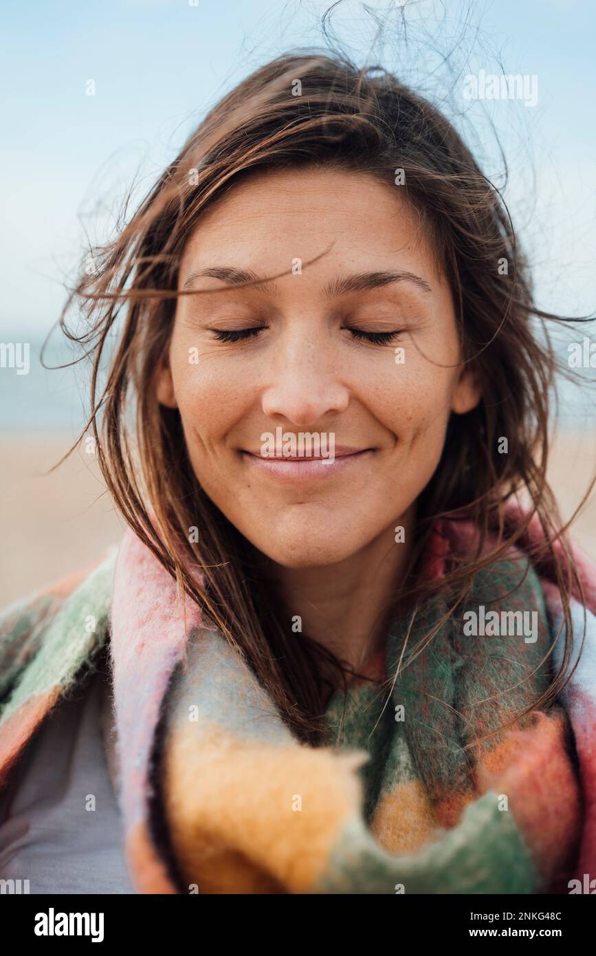 Brunette femme souriant avec les yeux fermés Banque D'Images