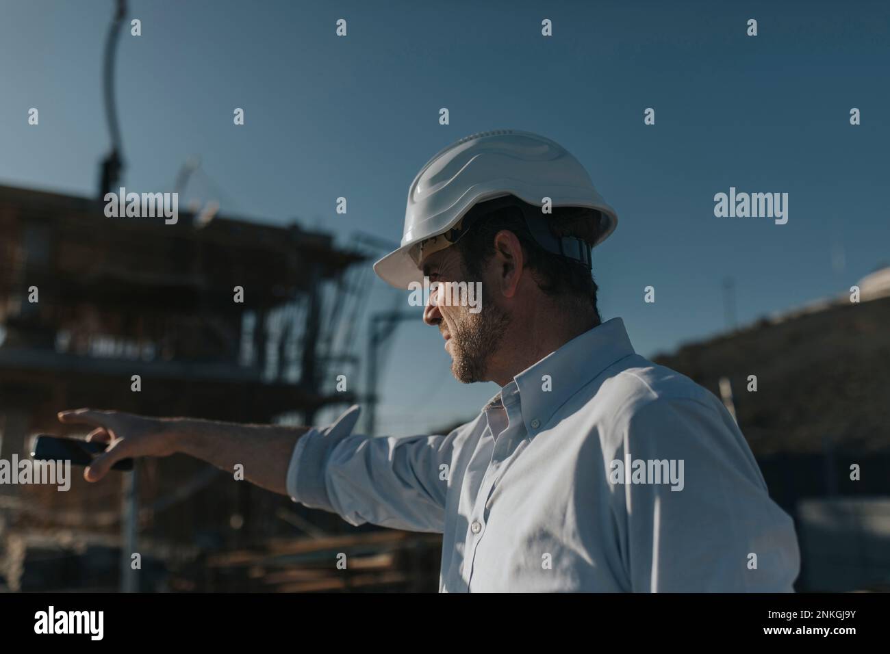 Un architecte se faisant un geste dans la zone de construction par beau temps Banque D'Images