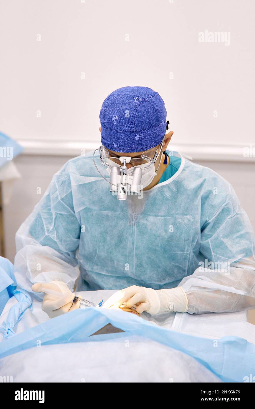 Chirurgien effectuant la chirurgie oculaire du patient Banque D'Images