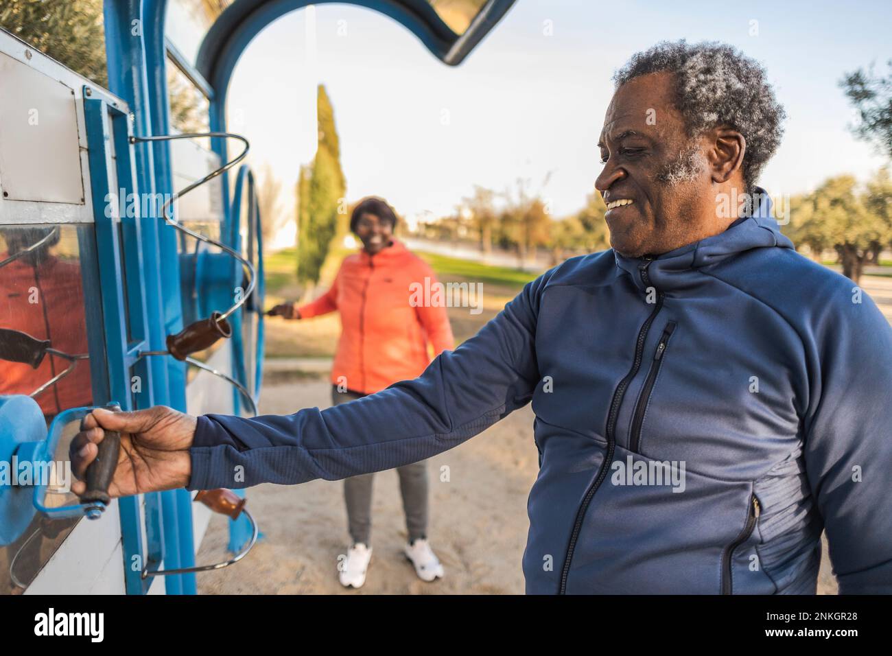 Homme senior heureux tenant des équipements d'exercice dans le parc Banque D'Images