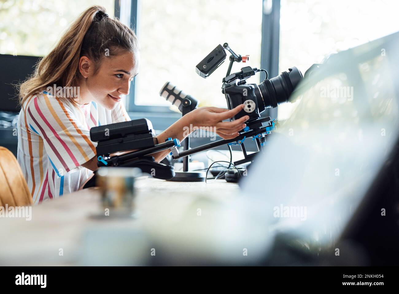 Femme d'affaires souriante utilisant un appareil photo au bureau Banque D'Images
