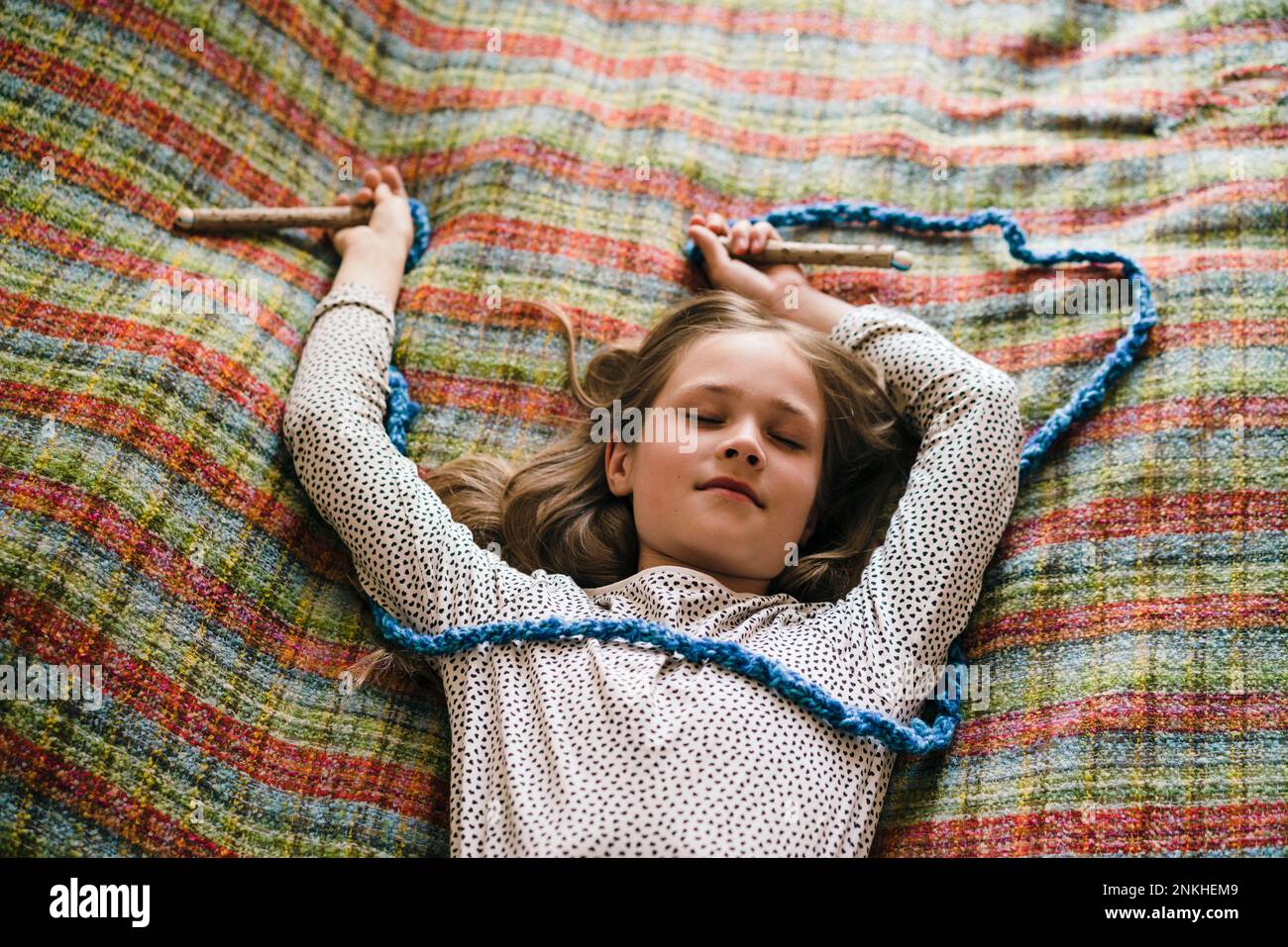 Fille avec corde à sauter dormir sur le lit à la maison Banque D'Images