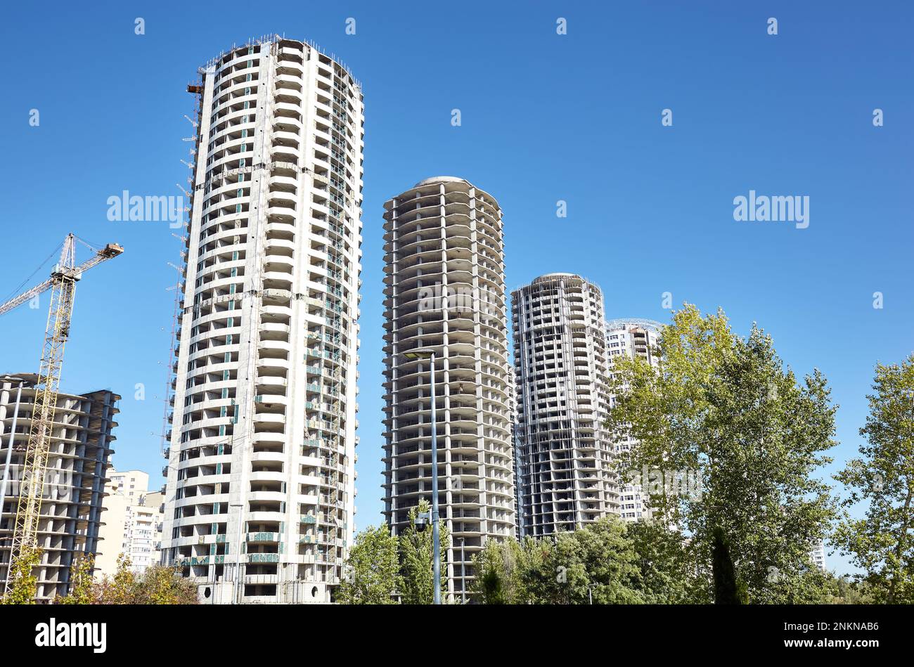 Tour grue construire une maison. Bâtiments en béton en construction contre le ciel. Chantier Banque D'Images