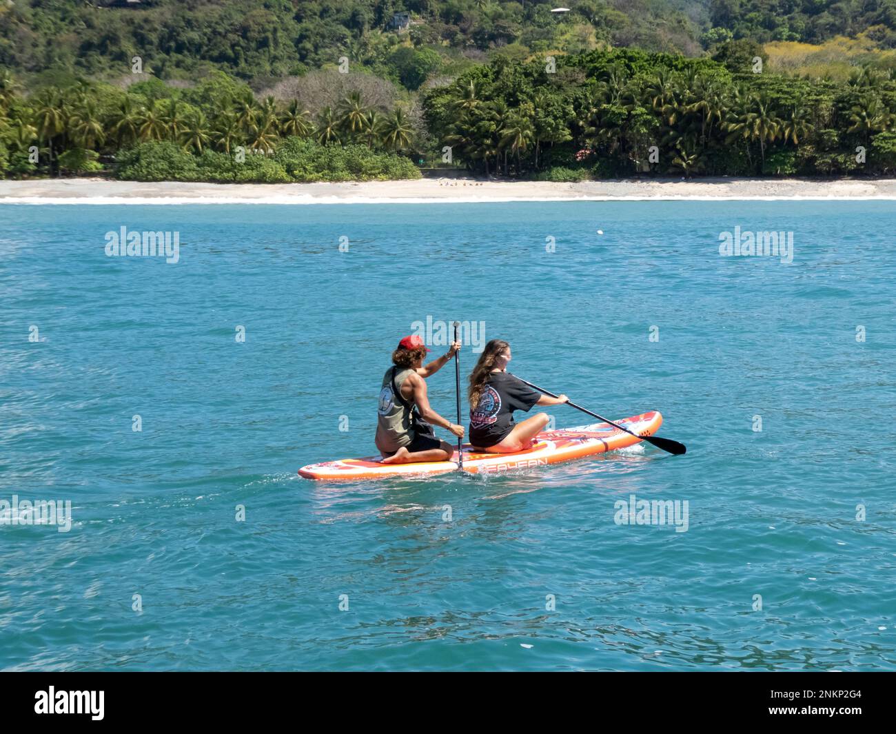 Un jeune couple pagayer un paddle le long de la côte en direction de Playa Malpais au Costa Rica Banque D'Images