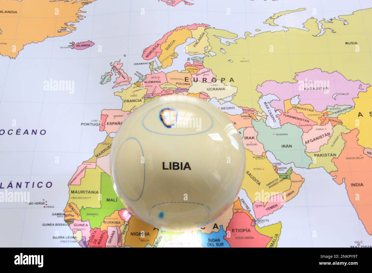 Boule de cristal sur une carte du monde qui met en évidence un pays pour le mettre en évidence comme une loupe et de noter son importance économique et financière Libia Banque D'Images