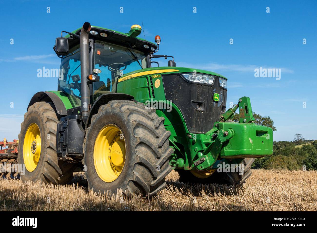 Grand tracteur John Deere 7280R rangs vert brillant avec pneus gros gros et herse à disques stationnés dans le champ de Leicestershire, en Angleterre, au Royaume-Uni Banque D'Images