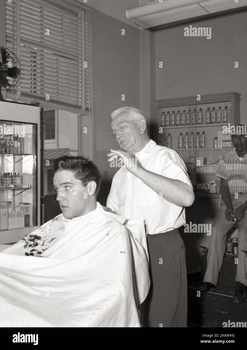 Elvis recevant une coupe de cheveux pour le film G.I. Blues, avril 1960 (juste après qu'il l'ait laissé plus longtemps après avoir été libéré de l'armée). Banque D'Images