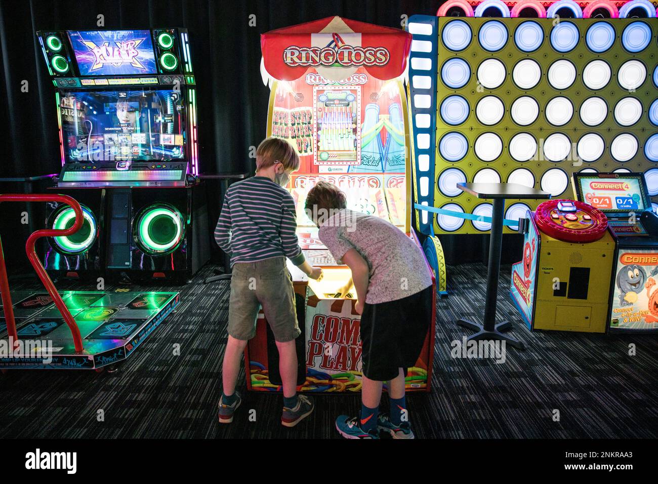 Deux garçons jouant un jeu Ring Toss dans l'arcade Banque D'Images