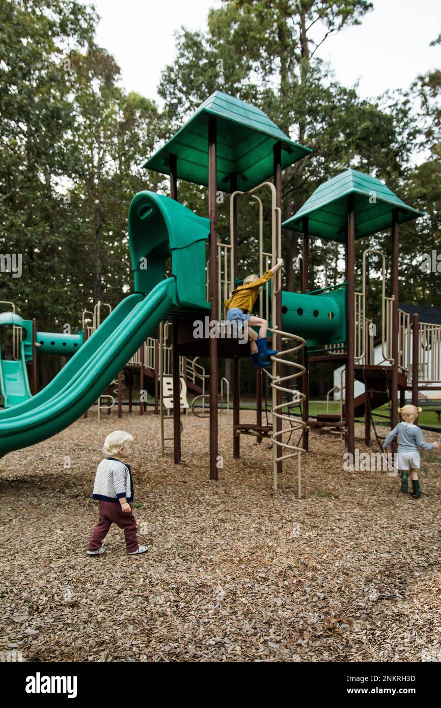 Enfants jouant sur le cadre d'escalade dans le parc de jeux Banque D'Images