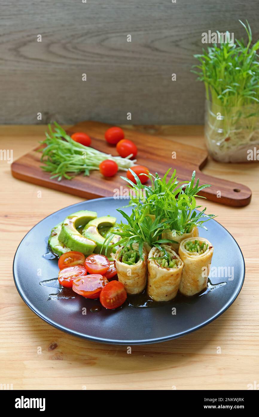 Délicieux petits pains aux épinards fraîchement récoltants et aux œufs, avec salade de tomates et d'avocat Banque D'Images