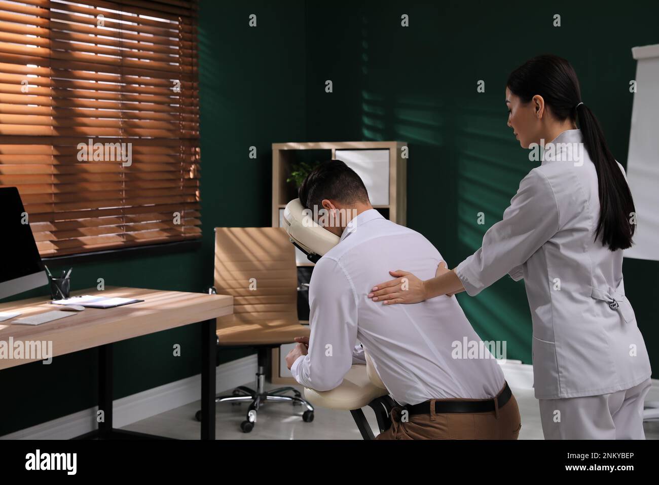 Homme recevant un massage dans une chaise moderne à l'intérieur Photo Stock  - Alamy