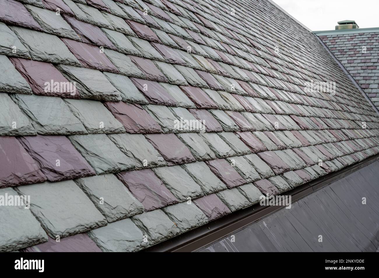 Tuiles de toiture en ardoise sur un bâtiment historique. Matériau de couverture attrayant et durable. Banque D'Images
