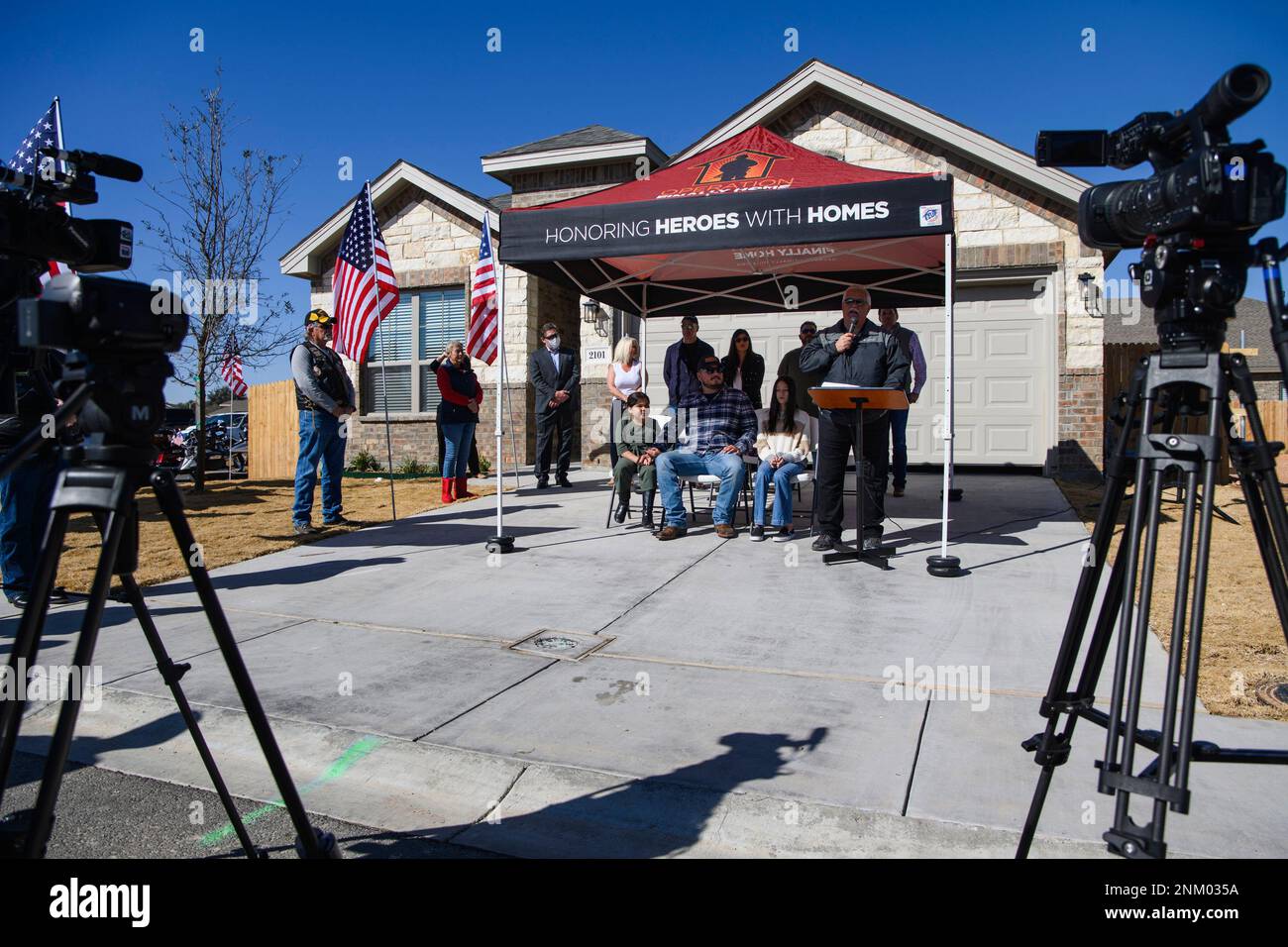 Disbaled United States Marine Corps veteran Corporal Ray Lopez sits with his two daughters Sarah, 9, and Madyson, 14, as he is presented with a new home provided by Operation Finally Home Thursday, Jan. 27, 2022, in Odessa, Texas. Operation Finally Home is a non-profit organization founded in 2005 and based out of New Braunfels with a mission to provide homes and home modifications to America's military heroes, first responders and widows of the fallen. (Eli Hartman/Odessa American via AP) Banque D'Images