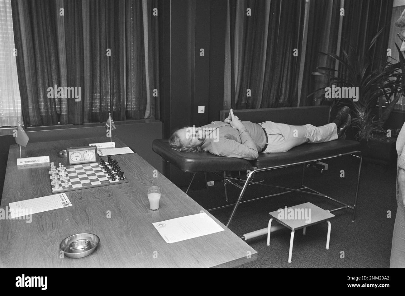 Tournoi d'échecs Interpolis Tilburg; Tony Miles (avec des problèmes de dos) est couché sur une table de massage attendant son adversaire ca. 1985 Banque D'Images