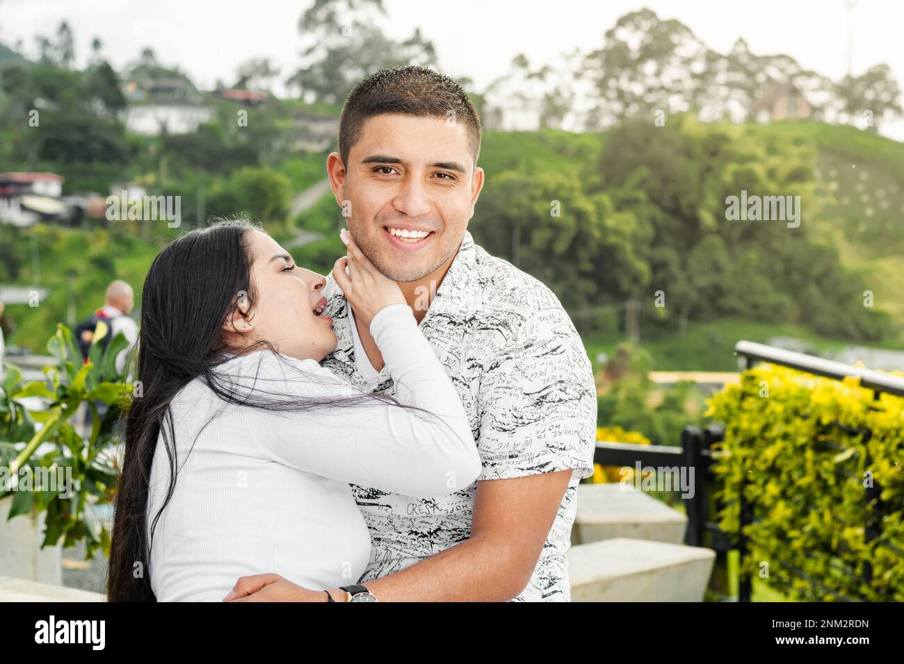 jeunes latinos, femme en train de faire des lamentations pendant que l'homme rit. fille pleurant sur l'épaule de son petit ami. Banque D'Images