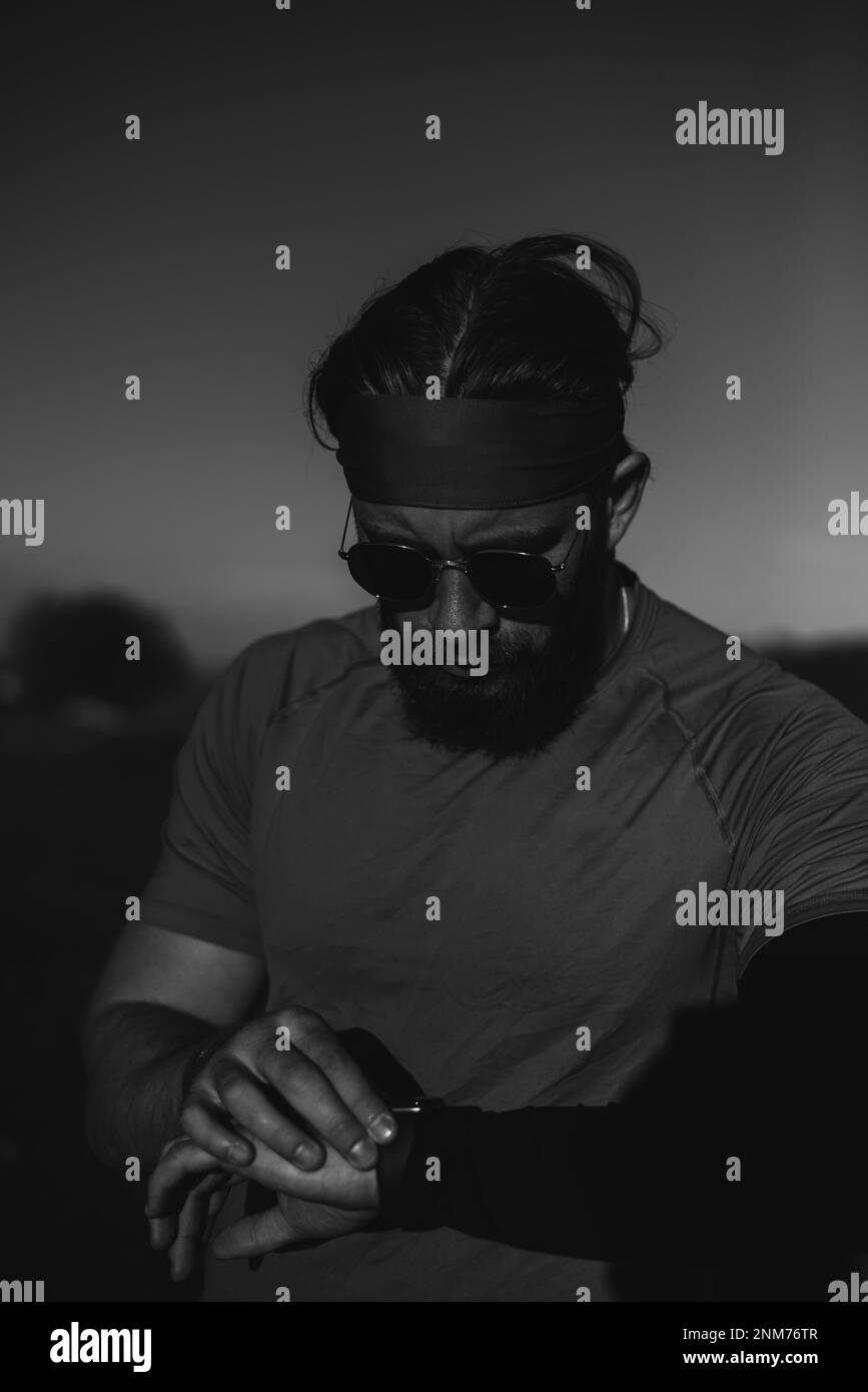 Un athlète déterminé se préparant au début de l'entraînement sur le sommet de la montagne au lever du soleil. Banque D'Images